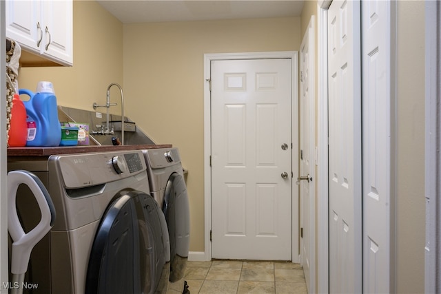 clothes washing area featuring light tile patterned floors, cabinets, and separate washer and dryer