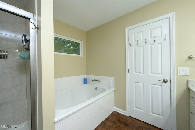 bathroom with hardwood / wood-style flooring, shower with separate bathtub, and vanity