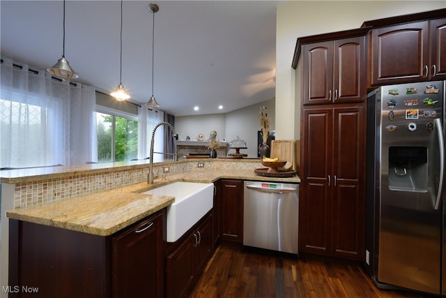 kitchen with decorative light fixtures, stainless steel appliances, dark hardwood / wood-style flooring, sink, and kitchen peninsula