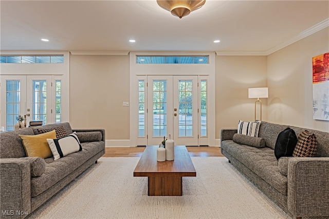 living room with crown molding, light hardwood / wood-style flooring, and french doors