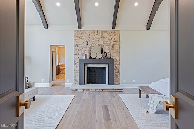 living room featuring a fireplace, wood-type flooring, and lofted ceiling with beams