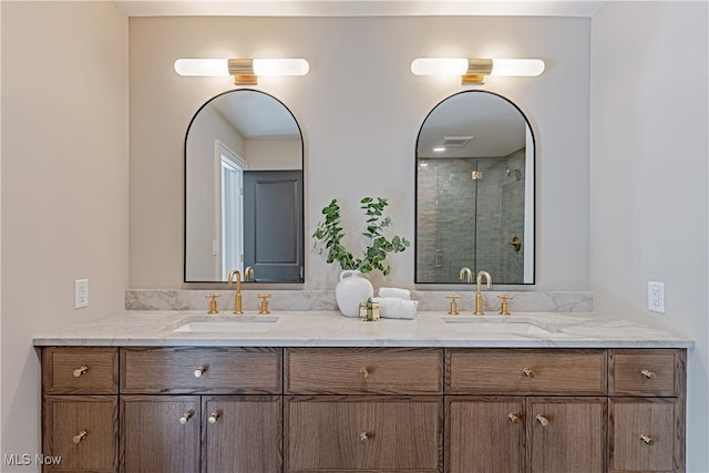 bathroom with a shower with shower door and vanity