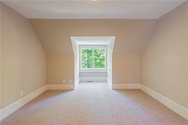 additional living space with lofted ceiling and light carpet