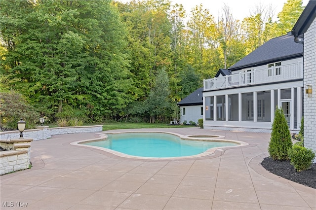 view of swimming pool featuring an in ground hot tub, a patio area, and a sunroom