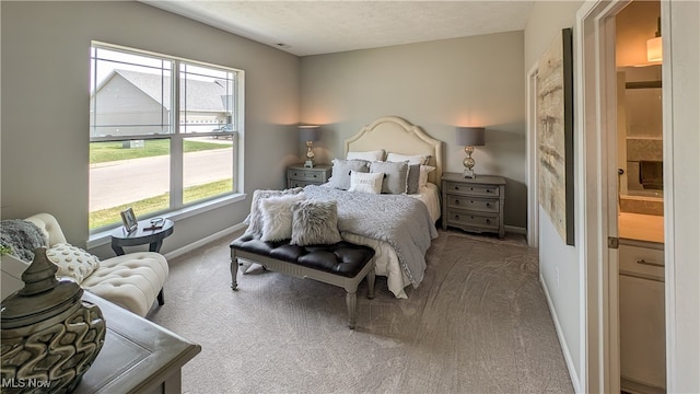 carpeted bedroom with a textured ceiling and ensuite bathroom