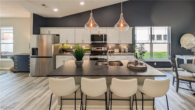 kitchen featuring appliances with stainless steel finishes, plenty of natural light, sink, and white cabinets