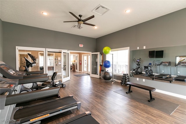 workout area featuring high vaulted ceiling, a textured ceiling, ceiling fan, french doors, and hardwood / wood-style floors