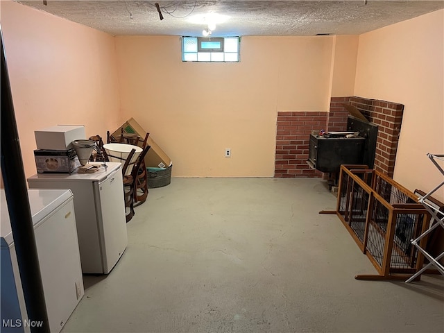 laundry room featuring a fireplace, a textured ceiling, and washing machine and clothes dryer