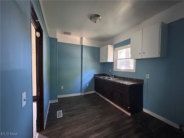 kitchen featuring dark wood-type flooring, white cabinets, and sink