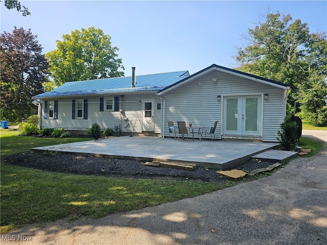 back of property featuring a lawn, french doors, and a patio area