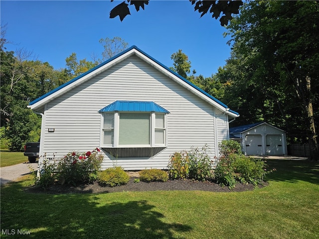 view of side of property with a lawn, an outdoor structure, and a garage