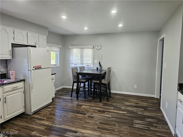 dining room with a textured ceiling and dark hardwood / wood-style floors