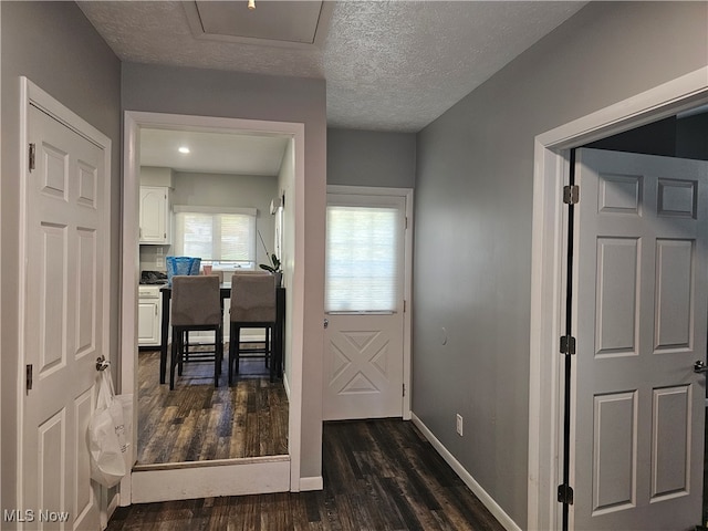 hall featuring a textured ceiling and dark hardwood / wood-style floors