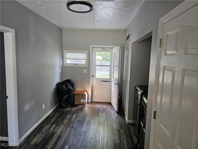 washroom with washer and clothes dryer, a textured ceiling, and dark wood-type flooring