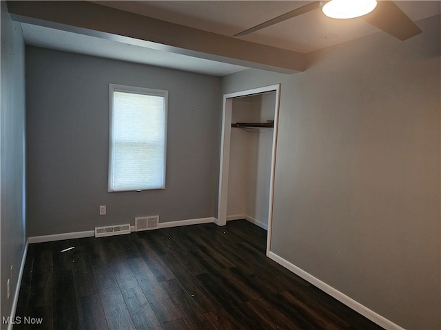 unfurnished bedroom featuring ceiling fan, dark wood-type flooring, and a closet