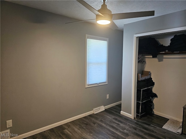 unfurnished living room with a textured ceiling, ceiling fan, and dark hardwood / wood-style flooring