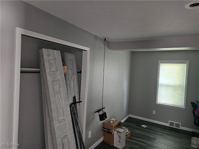 interior space with a textured ceiling and wood-type flooring