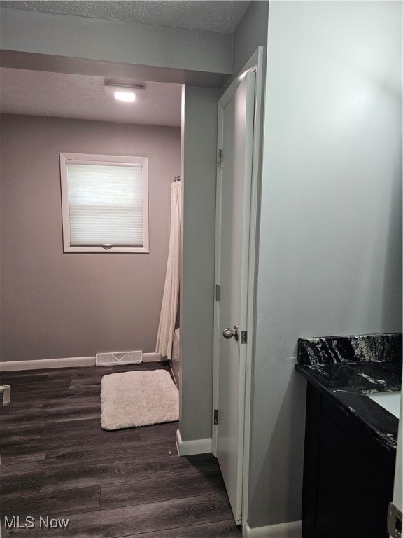 bathroom with a textured ceiling, vanity, and hardwood / wood-style flooring