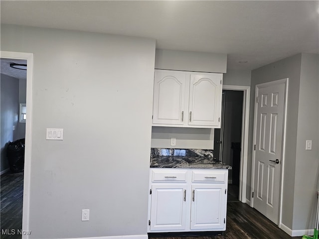 kitchen with dark hardwood / wood-style floors and white cabinets