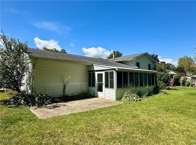 rear view of property with a sunroom and a yard