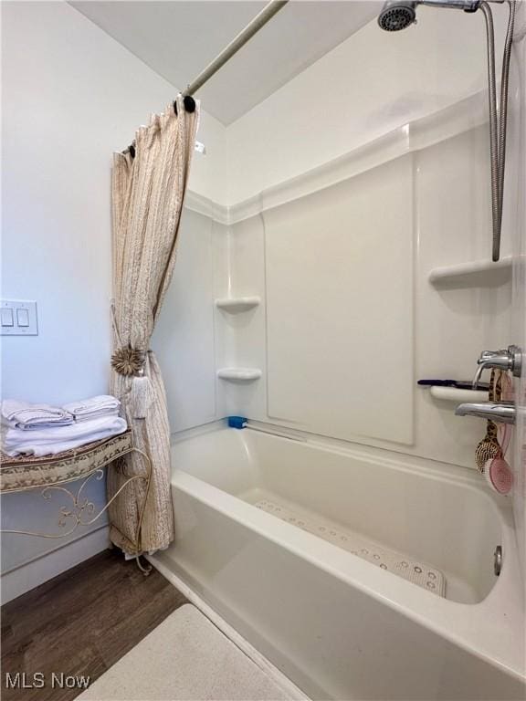 bathroom featuring hardwood / wood-style flooring and shower / tub combo