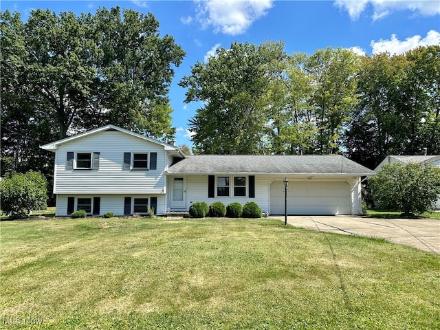 tri-level home featuring a garage and a front yard