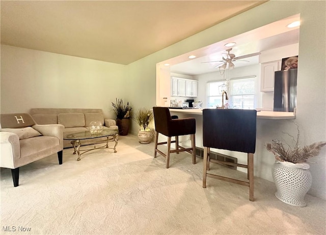 living room featuring light colored carpet and ceiling fan