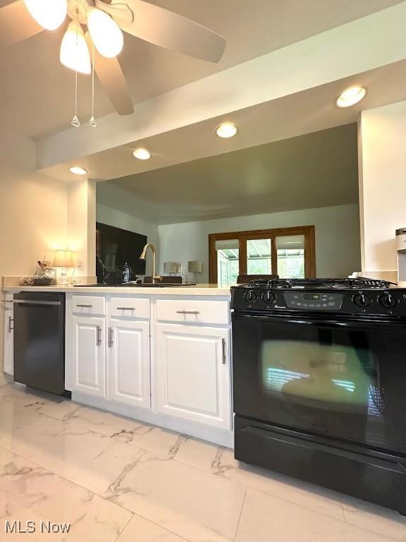 kitchen with white cabinetry, sink, ceiling fan, and black gas stove