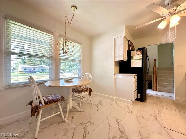 dining area with ceiling fan with notable chandelier