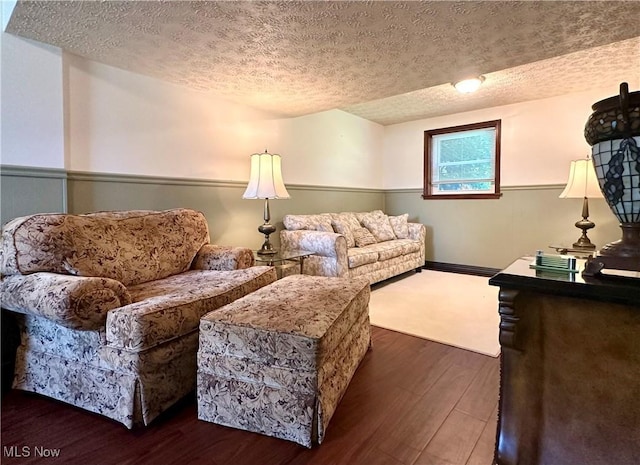 living room with dark hardwood / wood-style floors and a textured ceiling