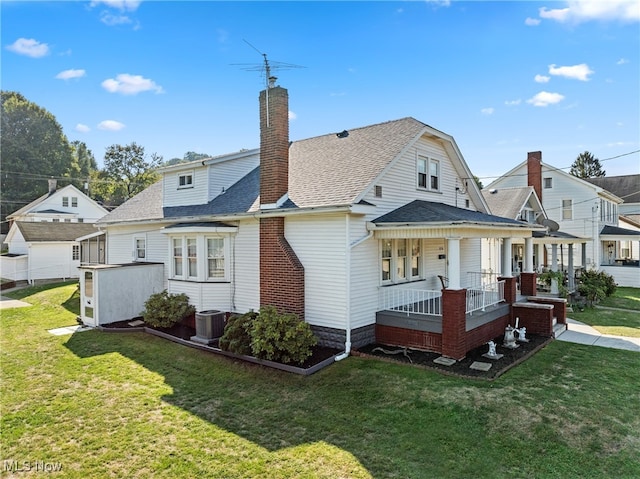 back of house with cooling unit, a lawn, and a porch