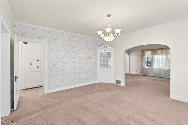 carpeted empty room featuring electric panel, a chandelier, and crown molding