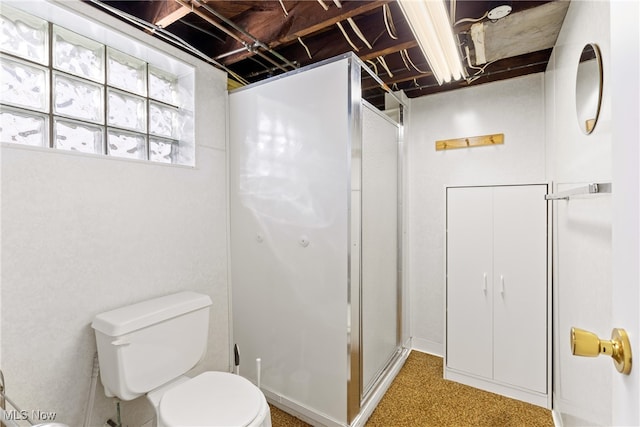 bathroom with toilet and a shower with door