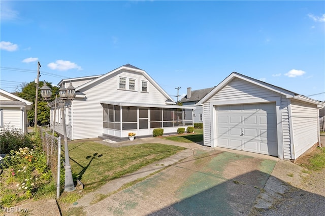 view of front of house featuring a garage, a sunroom, and a front lawn