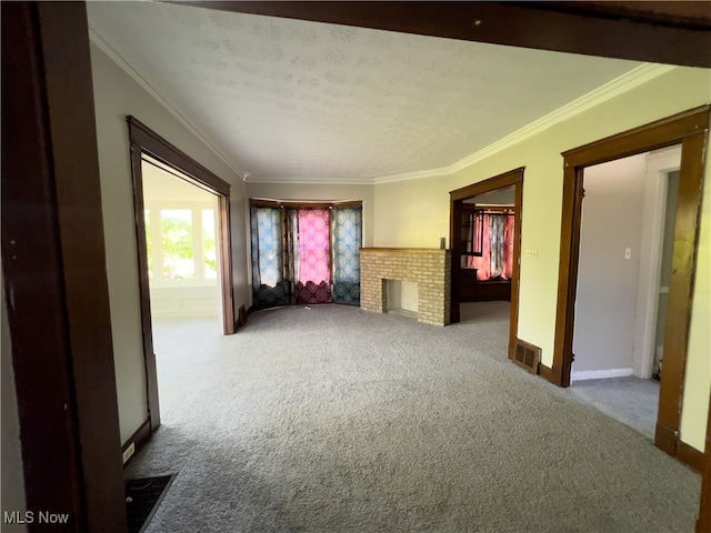 interior space featuring a textured ceiling, ornamental molding, carpet floors, and a fireplace