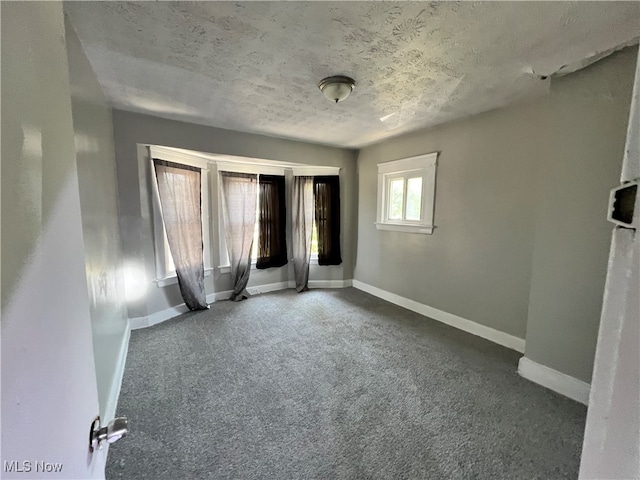 unfurnished bedroom with a textured ceiling and carpet floors