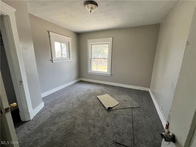 carpeted empty room with a textured ceiling