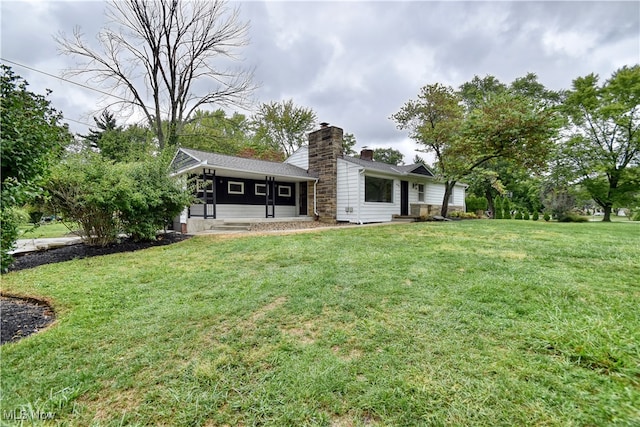 rear view of property with a lawn