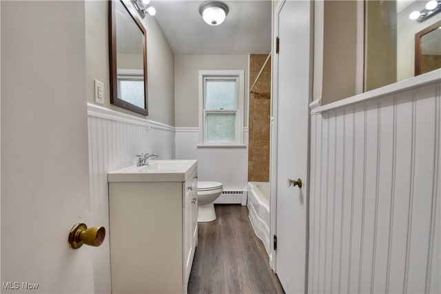 full bathroom featuring vanity, a baseboard radiator, hardwood / wood-style floors, toilet, and tiled shower / bath