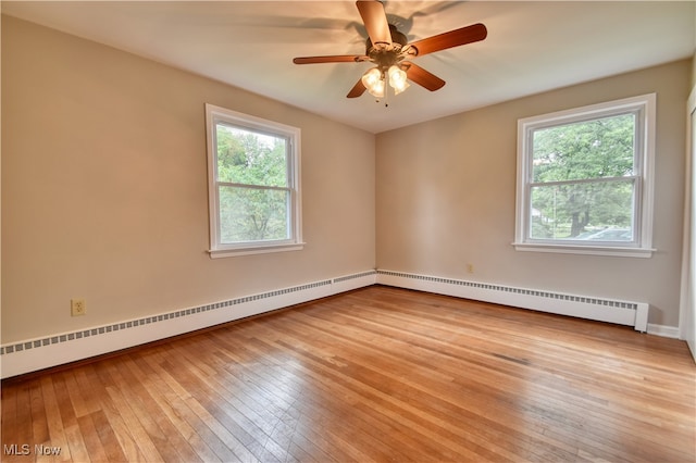 spare room with light wood-type flooring, baseboard heating, ceiling fan, and a healthy amount of sunlight