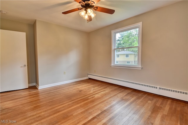 empty room featuring ceiling fan, baseboard heating, and light hardwood / wood-style flooring