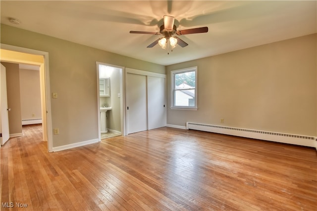 unfurnished bedroom with ensuite bath, light hardwood / wood-style flooring, a baseboard radiator, and ceiling fan