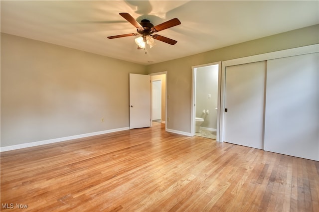 unfurnished bedroom with light wood-type flooring, connected bathroom, ceiling fan, and a closet