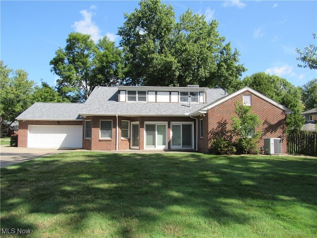 view of front of house with central AC, a front yard, and a garage