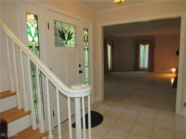 foyer featuring crown molding and light colored carpet