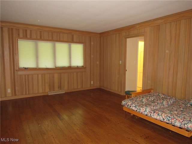 empty room featuring wooden walls and dark hardwood / wood-style floors