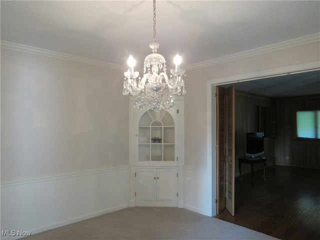 unfurnished room with crown molding, hardwood / wood-style flooring, and an inviting chandelier