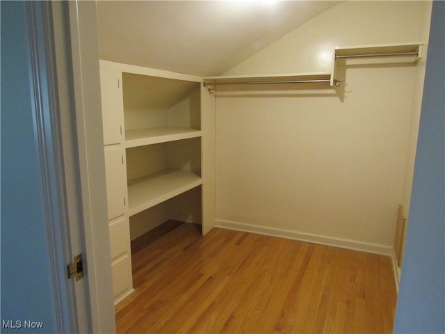 spacious closet featuring lofted ceiling and light hardwood / wood-style floors