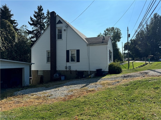 view of property exterior with an outbuilding, a yard, and a garage