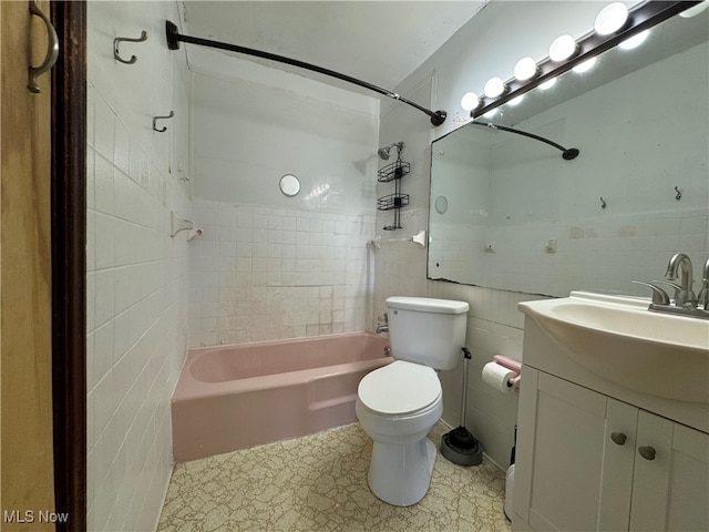 full bathroom with tiled shower / bath combo, vanity, toilet, and tile walls